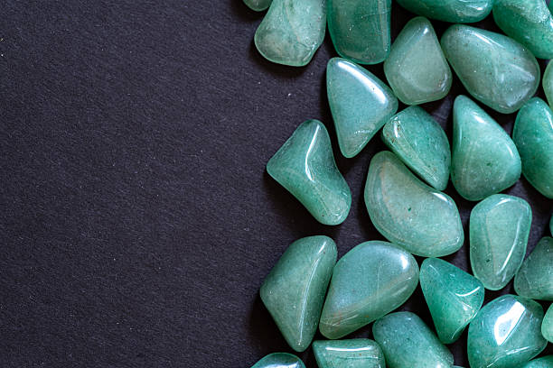 istock Beautiful green natural stones lined up against a black background 2247238978