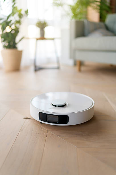 istock White robotic vacuum cleaner on wooden floor 2247242687