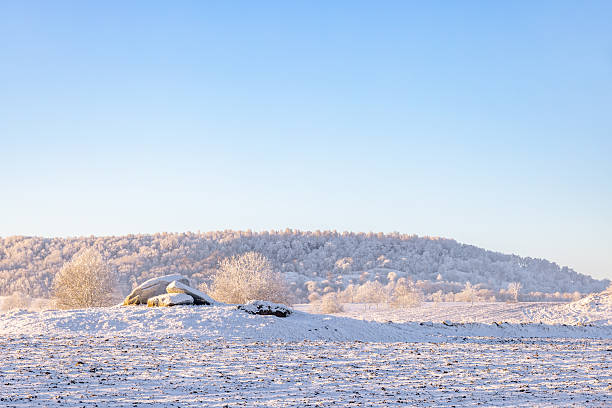 Passage grave on a hill by a mountain a cold snowy winter day