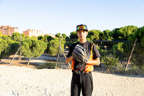 Young baseball player holding glove on field