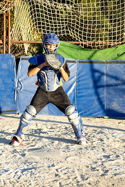 A 5 year old girl wearing a baseball uniform on a field.