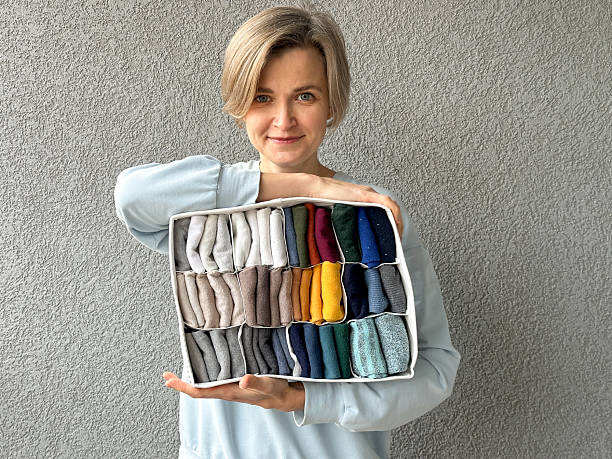 istock Woman presenting a box with color-organized folded clothes 2247246512