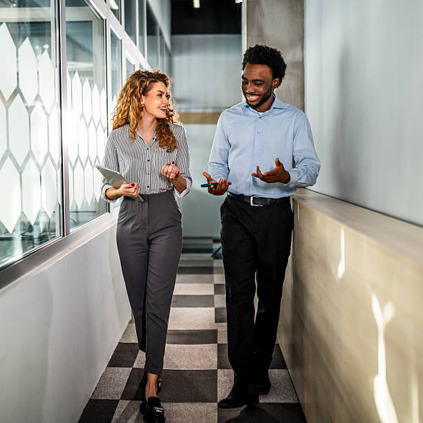 istock Business colleagues talking in modern office hallway 2247248868