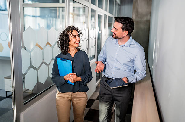 istock Business colleagues walking hallway discussing corporate project 2247249612