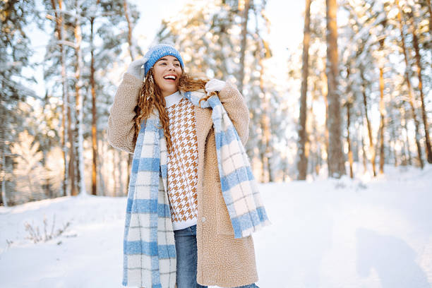 istock A smiling woman is having fun in a snowy forest. 2247249719