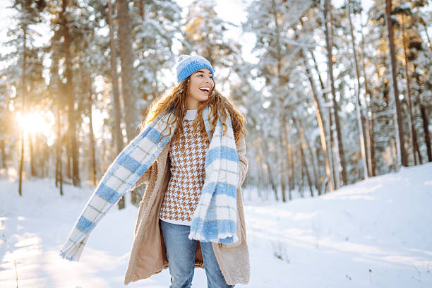 istock A smiling woman is having fun in a snowy forest. 2247249735