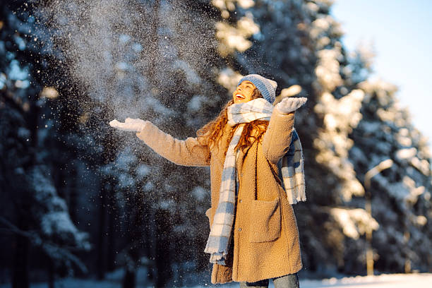 istock A smiling woman is having fun in a snowy forest. 2247249738