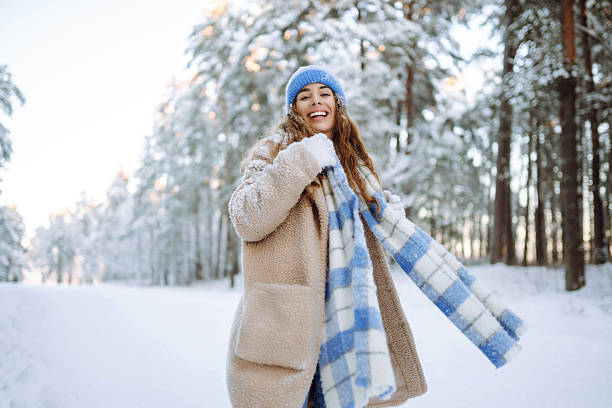 istock A smiling woman is having fun in a snowy forest. 2247249770