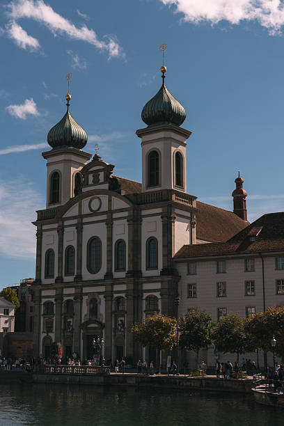 Baroque jesuit church standing by reuss river in historic lucerne, switzerland