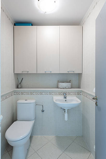 istock Modern Clean Bathroom Interior with White Fixtures and Storage Cabinets 2247251377