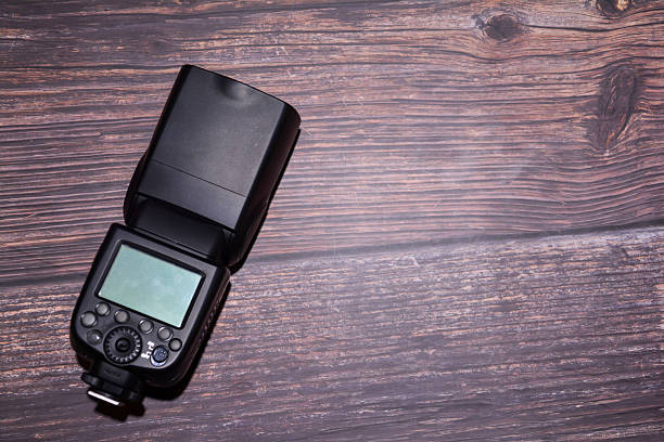 Camera flash on wooden background. Top view with copy space for your text. Flash light vor camera. Photo studio