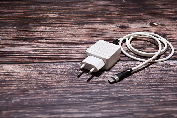 istock An adapter and USB cable for charging a mobile phone. A white Type-C cable with an adapter on a table. White USB cable on a wooden background. 2247251719