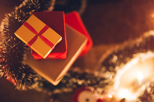 A stack of Christmas gifts on the floor indoors.