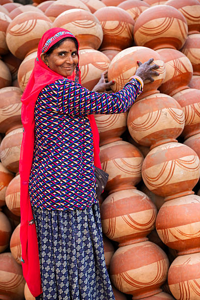 istock Pottery vendor arranging stacked earthen pots — Jaipur, India 2247254433