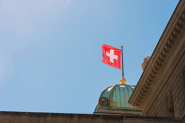 istock Swiss flag flying high on government building dome 2247254739