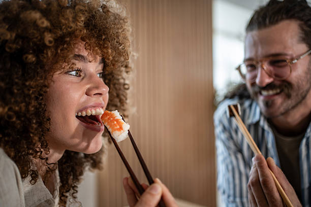 istock Happy couple eating sushi sharing romantic date 2247255025