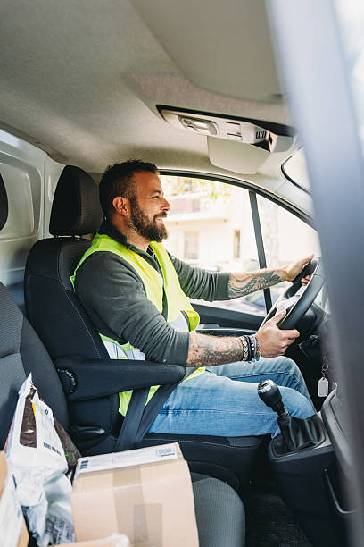 istock Smiling delivery man wearing high vis vest driving van 2247258880