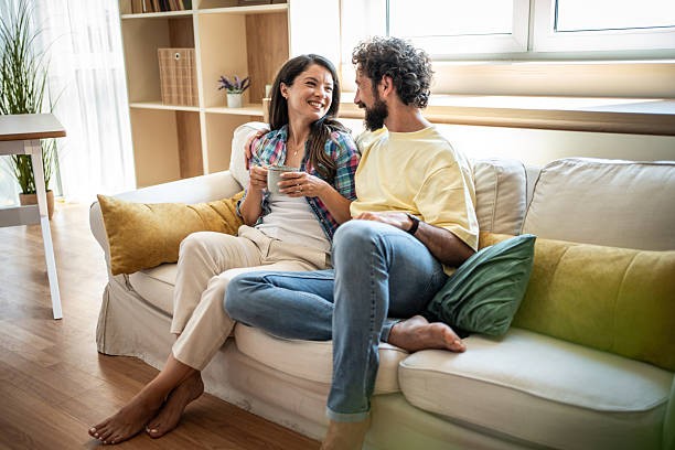 istock Happy couple relaxing on sofa enjoying morning coffee 2247259306