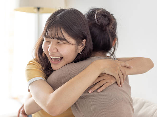 istock Happy asian girls embraced in a friendly hug 2247259313