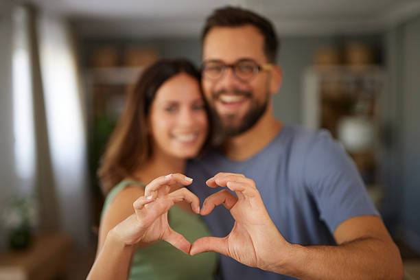 istock Happy couple forming heart shape with hands showing love 2247263005