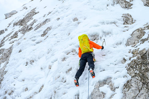 istock Determined Ice Climber Scaling Steep Frozen Wall with Intense Focus and Gear 2247264119