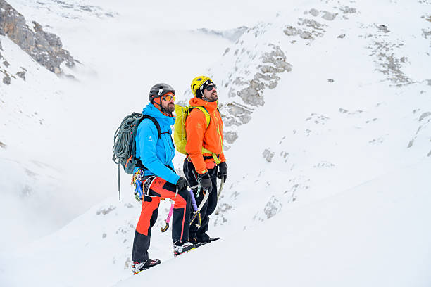istock Mountaineers Pausing on Snowy Slope with Misty Mountain Backdrop 2247264183
