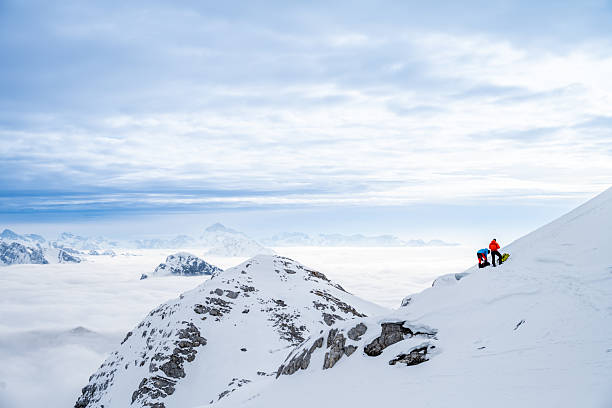 istock Winter Mountaineers Pausing on Snowy Slope with Misty Mountain Range in View 2247264208