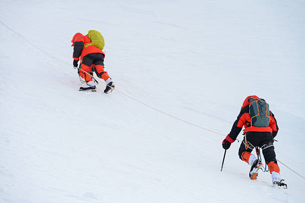istock High-altitude Climbers in Bright Gear Tackling Snow-covered High Mountain Slope 2247264219