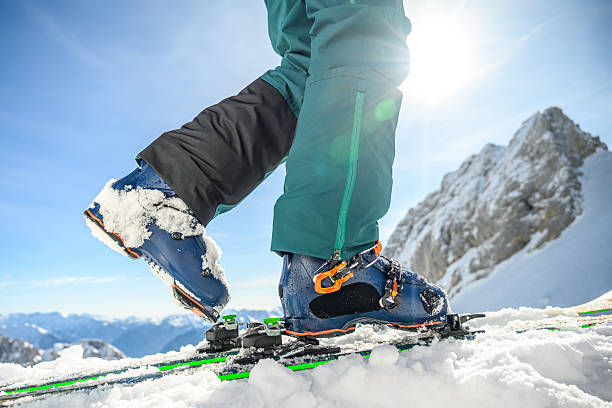 Old black leather ski boots isolated on white.