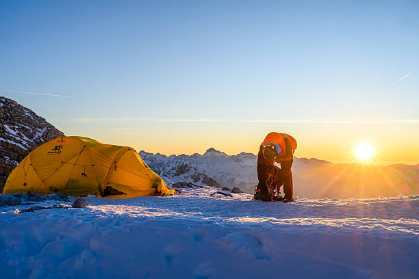 istock Mountaineer Organizing Gear at Snowy High Mountain Base Camp During Sunrise 2247270471