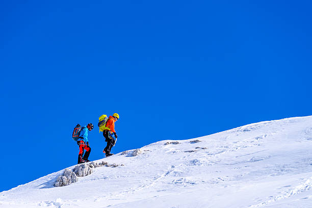 istock Mature Caucasian Male Climbers Progressing up Snowy Slope Under Bright Blue Sky 2247270504