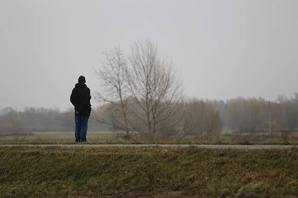 Sandomierz, Poland - November 08, 2025: Solitary Figure on a Grassy Hill in misty Weather