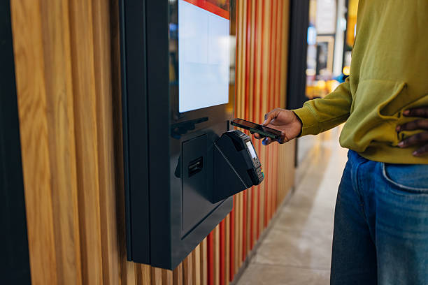 istock Unrecognizable man making a contactless payment with his mobile phone at a self-service kiosk in a modern quick-service restaurant 2247272506