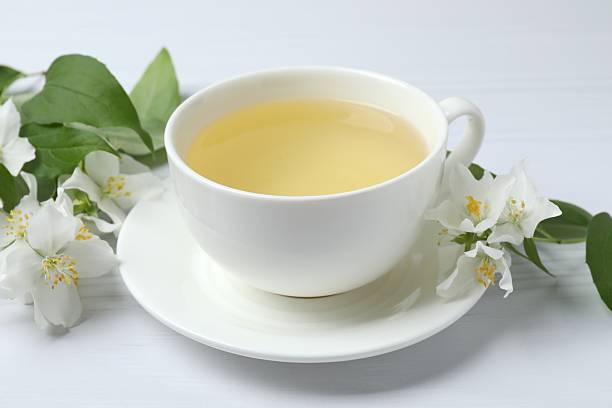 istock Cup of tea with jasmine flowers on white background, top view 2247273409