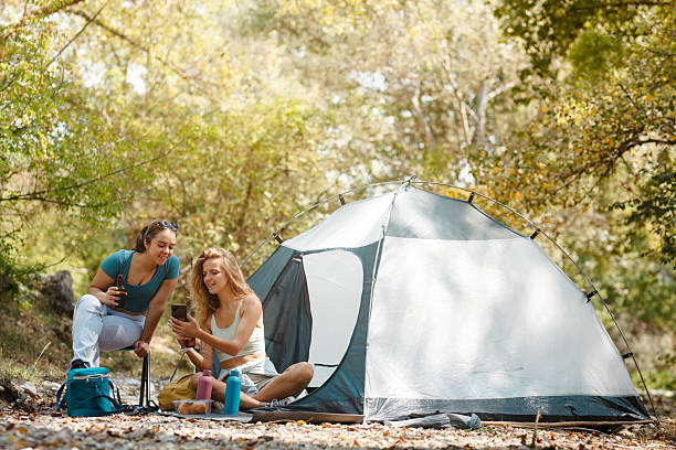 istock Friends enjoying a relaxed camping moment by their tent in a beautiful forest setting during the day surrounded by nature and trees 2247277072