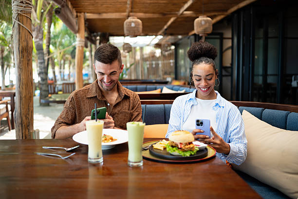 istock Young couple sharing dining experience at tropical restaurant, engaging with their online followers 2247277313