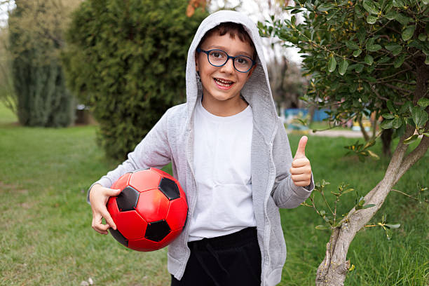 Cute boy with red and black football