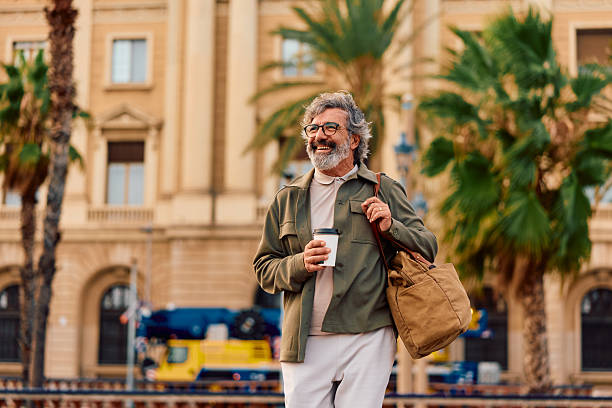 istock Smiling mature man walking in city with coffee 2247281353