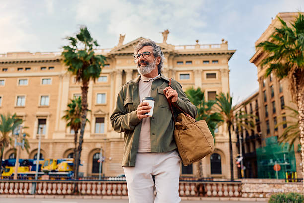 istock Mature man walking with coffee cup in Barcelona street 2247281973