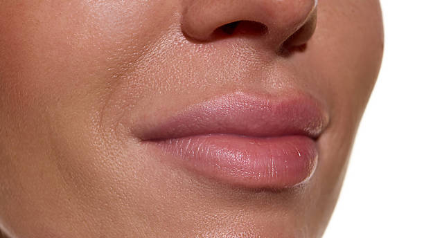 istock Lips close-up with smooth hydrated surface and soft natural tone 2247283772