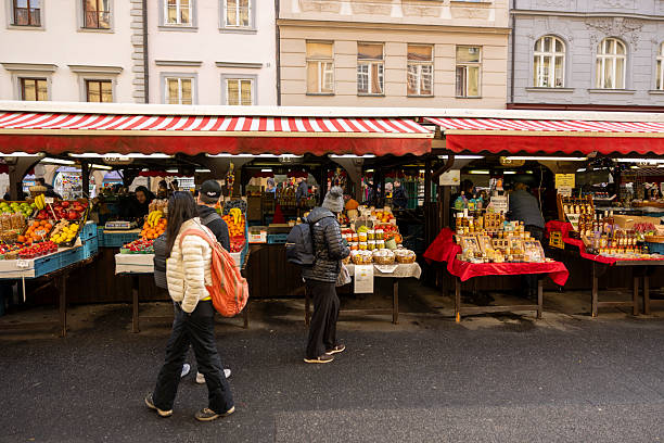 Czech Republic, Prag-November 12,2025: Tourists exploring Prague during a city tour while visiting the festive Christmas Market, with beautifully decorated stalls, historic architecture, and holiday lights creating a vibrant winter atmosphere