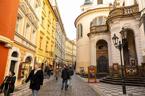 Czech Republic, Prag-November 12,2025: Tourists exploring Prague during a city tour while visiting the festive Christmas Market, with beautifully decorated stalls, historic architecture, and holiday lights creating a vibrant winter atmosphere