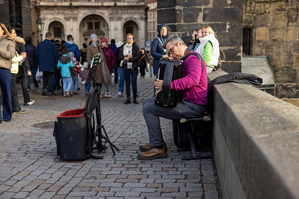 Czech Republic, Prag-November 12,2025: Tourists exploring Prague during a city tour while visiting the festive Christmas Market, with beautifully decorated stalls, historic architecture, and holiday lights creating a vibrant winter atmosphere