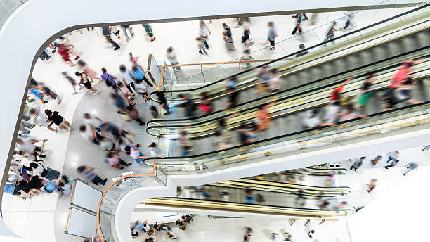 Crowed people in blurred motion on escalator at a shopping mall