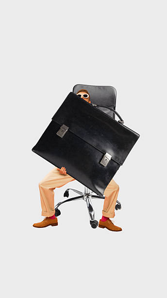 istock Creative collage. Person sitting on office chair holding oversized briefcase symbolizing job stress 2247285992
