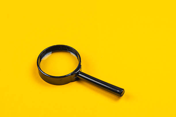 istock Simple black magnifying glass against a bright yellow background 2247286722