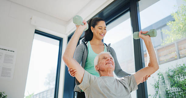 istock Personal trainer, senior man or dumbbell to support physical health, strength training or workout. Retirement fitness, below or coach helping with weightlifting challenge, people or wellness exercise 2247289749
