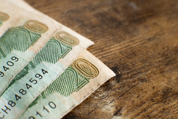 Close-up of a woman's hand counting a stack of paper bills, copy space