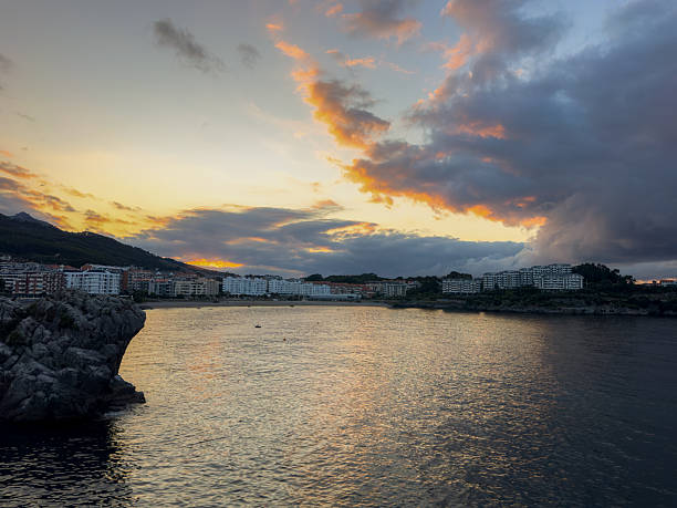 Sunset city on the coast and the sea under the clouds