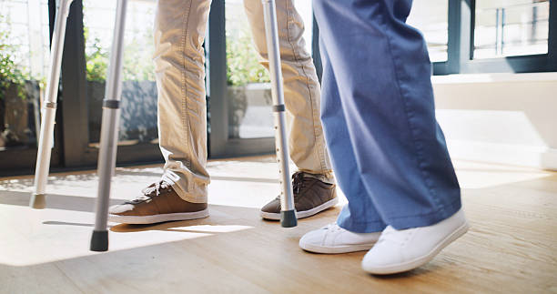 istock Physiotherapy, legs or people in center with walker, checkup or mobility support in rehabilitation. Healthcare, help or nurse in clinic with walking aid, consultation or assistance in muscle recovery 2247291132